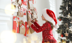 (Crédits photo : Adobe Stock - Petite fille en habit de Noël ouvrant une fenêtre du calendrier de l'Avent)