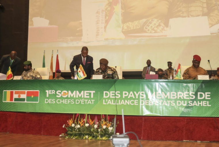 Le chef de la junte du Niger, le général Abdourahamane Tiani (C), le général malien Assimi Goïta (G) et le capitaine burkinabè Ibrahim Traoré (D) signent la charte portant création de la Confédération des États du Sahel (AES) lors de leur premier sommet à Niamey le 6 juillet 2024 au Niger ( AFP / - )