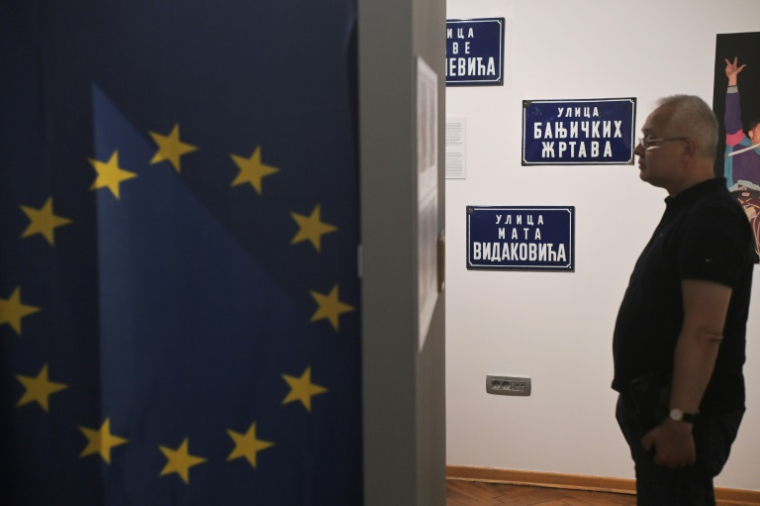 Un visiteur pendant l'exposition "Labyrinthe des années 90 : à la découverte des Balkans", dans une galerie à Belgrade, en Serbie, le 18 juin 2025 ( AFP / OLIVER BUNIC )