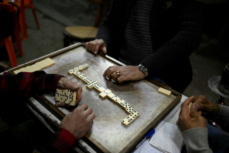 Des personnes jouent aux dominos à la terrasse d'un café avant la fermeture en application du couvre-feu, dans le centre-ville du Caire, le 2 avril 2026 en Egypte ( AFP / Khaled DESOUKI )
