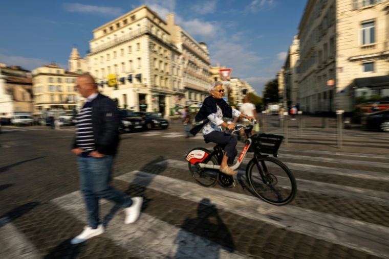 Piéton et cycliste dans le quartier du Vieux Port à Marseille, le 14 octobre 2025 ( AFP / Miguel MEDINA )