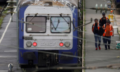 Des ouvriers passent devant des trains régionaux TER au dépôt SNCF d'Hellemmes-Lille