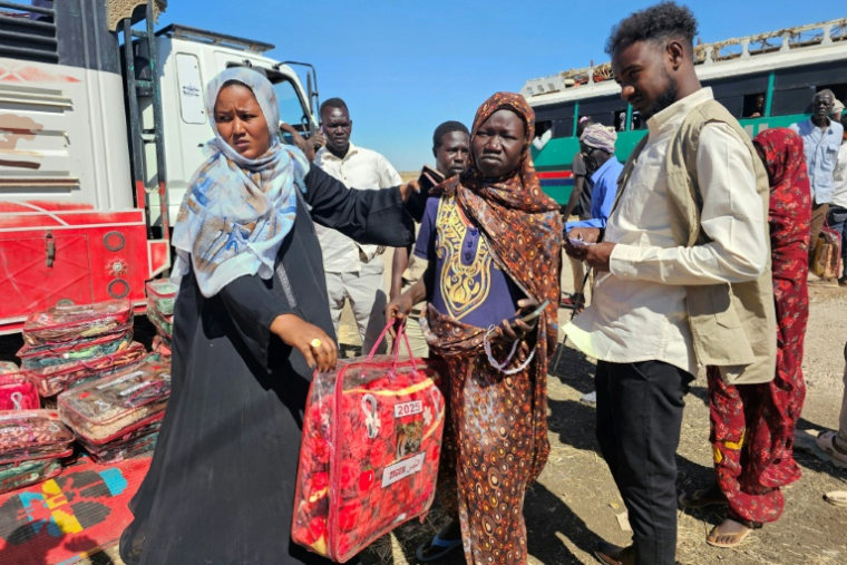Des déplacés soudanais reçoivent des couvertures dans le camp d'Abou al-Naga, dans l'Etat de Gedaref à environ 400 kilomètres à l'est de Khartoum, le 30 décembre 2025 ( AFP / Abdulrahman GUMAA )