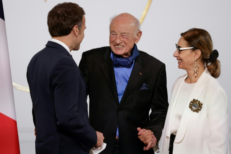 Le président Emmanuel Macron (gauche) salue le philosophe et sociologue Edgar Morin et son épouse Sabah Abouessalam, lors d'une cérémonie à l'Elysée pour fêter les 100 ans de l'intellectuel français, le 8 juillet 2021 ( POOL / Yoan VALAT )