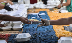 Des volontaires coupent des parts du gâteau géant aux couleurs du Venezuela pour les distribuer dans les abris où les victimes du tremblement de terre du 24 juin sont réfugiées, le 18 juillet à Caracas ( AFP / Juan BARRETO )