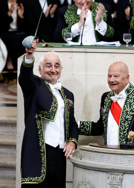 Le chef français Guy Savoy l(à gauche brandissant son épée d'académicien) lors de son installation à l'Académie des Beaux-Arts à Paris le 20 mai 2026 ( AFP / SIMON WOHLFAHRT )