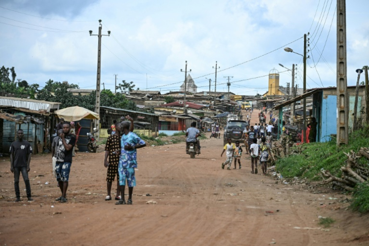 Des habitants dans une rue de Lopou, village voisin de Dabou, à l'ouest d'Abidjan, le 16 octobre 2025 en Côte d'Ivoire ( AFP / Sia KAMBOU )