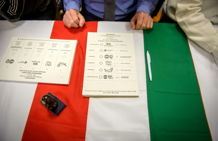Des bulletins de vote sont placés sur un drapeau hongrois dans un bureau de vote à Budapest, au début des élections législatives en Hongrie, le 12 avril 2026 ( AFP / Ferenc ISZA )