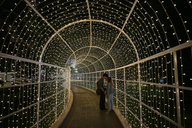 Un couple d'amoureux sous les décorations de Noël à Caracas, le 19 décembre 2025 au Venezuela ( AFP / Federico PARRA )