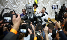 Count Binface (c) avec d'autres candidats,  après la proclamation des résultats de l’élection partielle de Clacton, dans l’est de l’Angleterre, le 14 août 2026 ( AFP / Henry NICHOLLS )