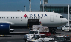 Un employé télécharge des colis dans un avion de Delta Air Lines à l'aéroport international John F. Kennedy dans le Queens, à New York