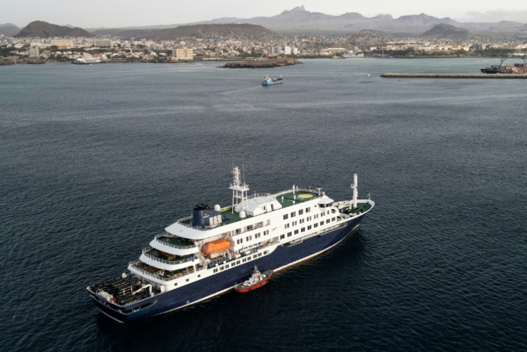 Vue aérienne de personnels de santé embarquant à bord du navire de croisière MV Hondius, au mouillage au large du port de Praia, le 6 mai 2026 au Cap-Vert ( AFP / - )
