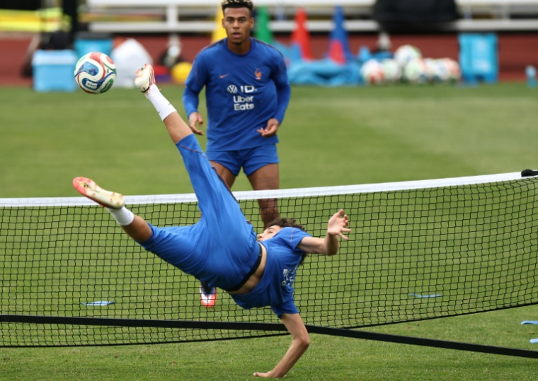 A l'entraînement lundi, le Français Maghnes Akliouche fait un geste acrobatique face à Désiré Doué, à la Bentley University de Waltham, près de Boston. ( AFP / FRANCK FIFE )