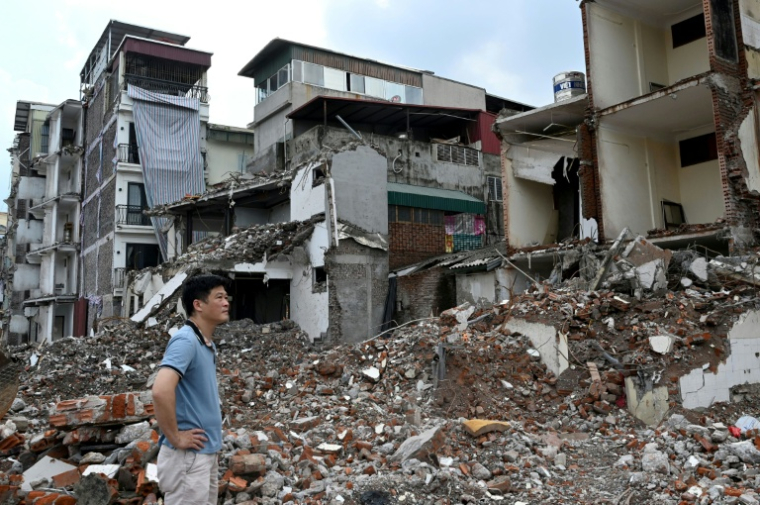 Un homme regarde sa maison démolie dans le cadre de grands travaux décidés par les autorités pour la capitale vietnamienne Hanoï, le 20 mai 2026 ( AFP / Nhac NGUYEN )