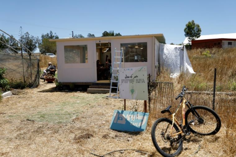 People sit at a makeshift coffeeshop at Ramat Trump Moshav in the Israeli-annexed Golan Heights on June 19, 2026. Perched on a hill in the Israeli-annexed Golan, residents of Trump Heights still trust the judgement of its namesake US president, despite a fragile Iran deal that most in Israel view as bad for their country. Under a US-Iran deal announced earlier this week to end the Middle East war, fighting is supposed to cease between Israel and Iran-backed militant group Hezbollah in Lebanon, just 15 kilometres (nine miles) north of Trump Heights. ( AFP / Jalaa MAREY )