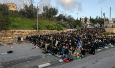 Des fidèles musulmans improvisent une prière devant les murailles de la Vieille ville de Jérusalem, le 20 mars 2026 ( AFP / AHMAD GHARABLI )