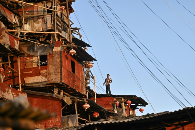 Chen Tianming devant sa "maison clou" à Xingyi, dans la province du Guizhou, le 20 mai 2025 au sud-ouest de la Chine ( AFP / Pedro PARDO )