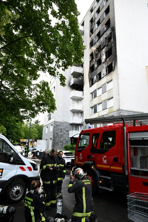 Des pompiers devant la façade noircie d'un immeuble où un incendie a fait quatre morts, le 6 juin 2025 à Reims ( AFP / FRANCOIS NASCIMBENI )