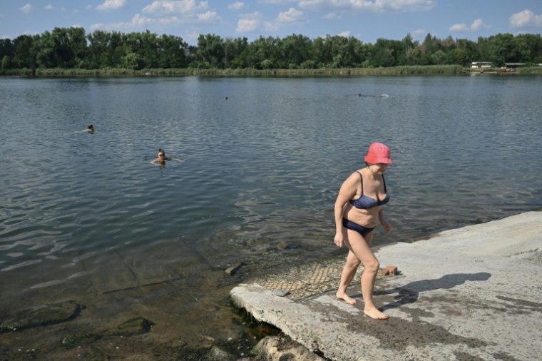 Raissa, 67 ans, sort de l'eau à Sloviansk, le 6 août 2025, dans la région de Donetsk ( AFP / Genya SAVILOV )