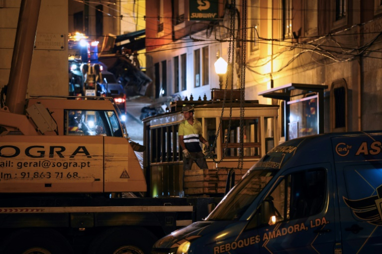 Des ouvriers déplacent l'épave d'un funiculaire au lendemain d'un accident à Lisbonne, le 4 septembre 2025 au Portugal ( AFP / PATRICIA DE MELO MOREIRA )