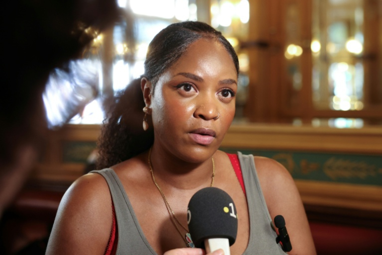 Lilith, membre du collectif Diasporas solidaires avec les victimes de l'empoisonnement colonial (Dsavec), parle aux journalistes après le non-lieu confirmé dans le scandale sanitaire du chlordécone, le 22 juin 2026 dans un café près du Palais de Justice à Paris ( AFP / Charlotte SIEMON )