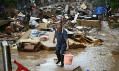 Un habitant récupère de l'eau de pluie dans une zone inondée après la rupture d'un réservoir près de Gantang, dans la région du Guangxi, le 9 juillet 2026 dans le sud-ouest de la Chine ( AFP / GREG BAKER )