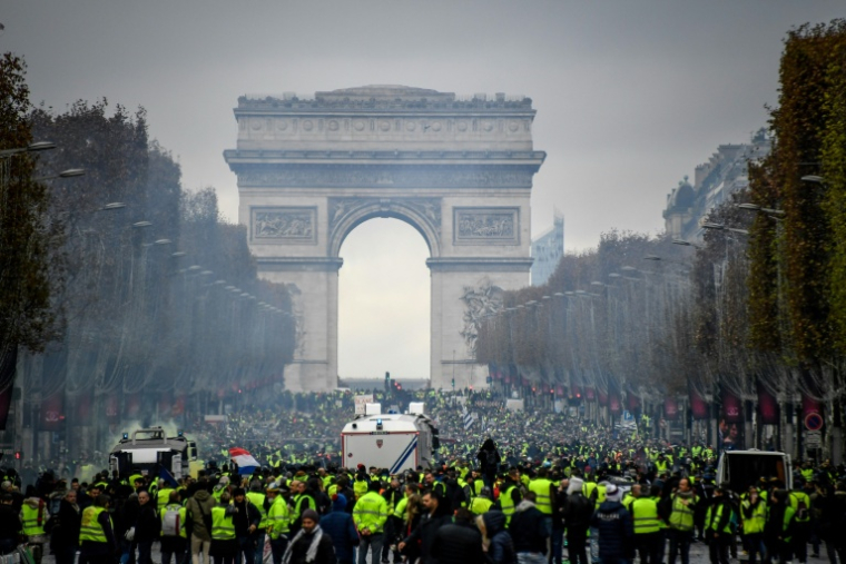 Des manifestants sur les Champs-Élysées, à Paris, le 24 novembre 2018, lors d'un rassemblement national du mouvement des "gilets jaunes"pour protester contre la hausse des prix du carburant et du coût de la vie ( AFP / Bertrand GUAY )