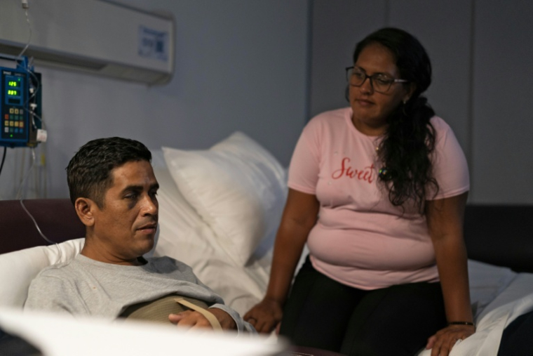 Hernan Gil, qui a survécu près de huit jours sous les décombres d'un immeuble à Catia La Mar après deux séismes survenus le 24 juin  dans l'Etat de La Guaira, est hospitalisé à Caracas, accompagné de sa compagne Rubesmal Gonzalez, le 5 juillet 2026 au Venezuela ( AFP / Rosali Hernandez )