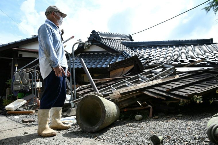 Un homme regarde sa maison effondrée à Hikawa, dans la préfecture de Kumamoto, le 30 juillet 2026, après le séisme qui a frappé le sud-ouest du Japon le 28 juillet ( JIJI Press / JIJI PRESS )