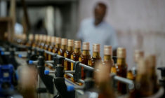 Des bouteilles de whisky Imperial sur une ligne de production à la distillerie Carew and Co. à Darsana, le 23 octobre 2025 dans le sud-ouest du Bangladesh ( AFP / Rehman ASAD )