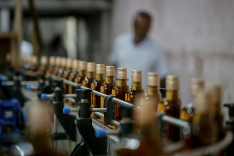Des bouteilles de whisky Imperial sur une ligne de production à la distillerie Carew and Co. à Darsana, le 23 octobre 2025 dans le sud-ouest du Bangladesh ( AFP / Rehman ASAD )