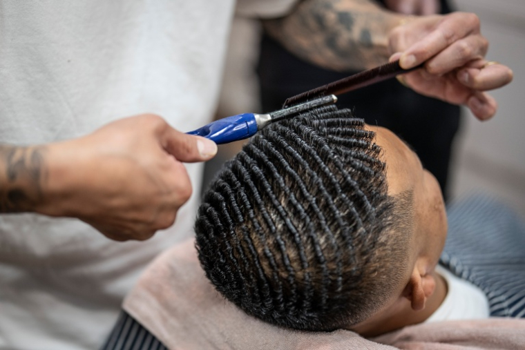 Le "punch perm", comme ici pratiqué sur Tekisasu le 27 août 2026, consiste à réaliser de petites boucles rigides avec les cheveux ( AFP / Yuichi YAMAZAKI )