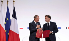Le Premier ministre polonais Donald Tusk (g) et le président français Emmanuel Macron se serrent la main après avoir signé un traité à l'issue de leur rencontre à Nancy, le 9 mai 2025 ( POOL / Christophe PETIT TESSON )