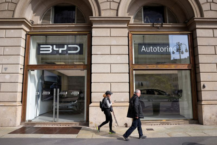Des personnes marchent devant un magasin BYD Auto à Milan