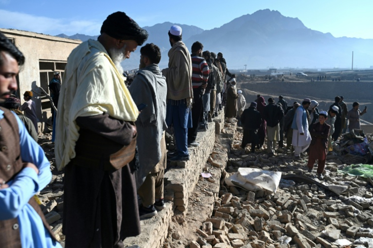 Des habitants se tiennent près d'habitations endommagées après des bombardements, en périphérie de Kaboul, Afghanistan, le 13 mars 2026 ( AFP / Wakil Kohsar )