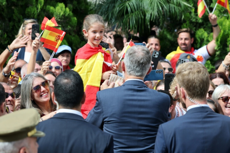 Le roi d'Espagne Felipe VI reçoit un cadeau d'une enfant dans la foule à Ceuta  le 13 octobre 2026 ( AFP / Thomas COEX )