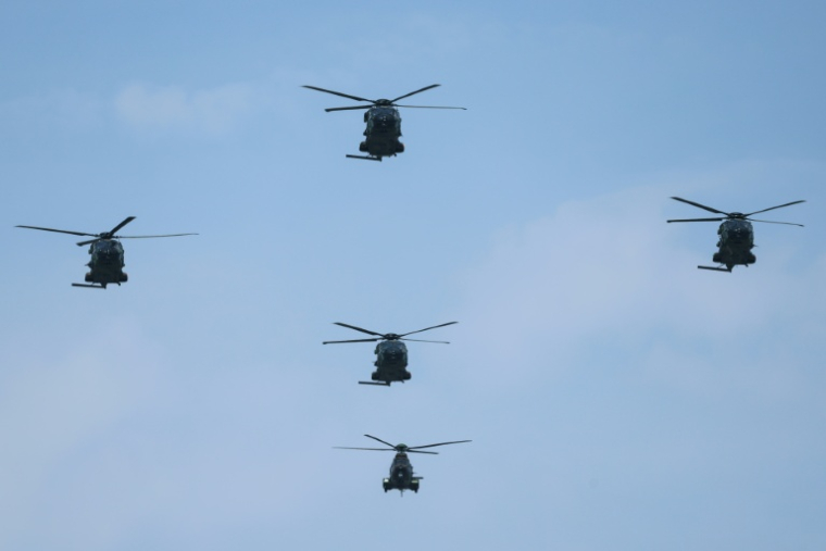 Des hélicoptères lors du défilé aérien militaire annuel au-dessus de l'avenue des Champs-Élysées, le 14 juillet 2026 à Paris ( AFP / Ludovic MARIN )