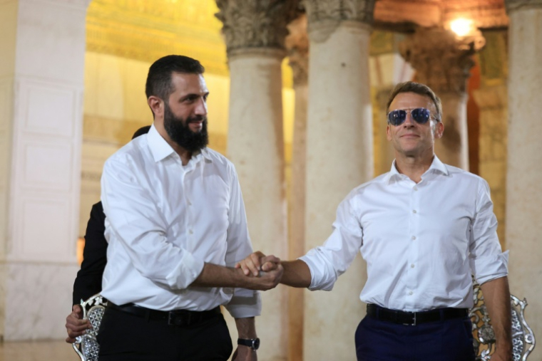Le président français Emmanuel Macron (à droite) serre la main du président syrien Ahmad al-Chareh lors d'une visite à la mosquée des Omeyyades, à Damas, le 6 juillet 2026. ( AFP / Ludovic MARIN )