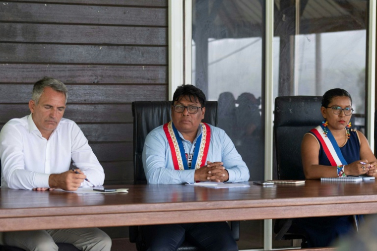 Photo diffusée le 11 mai 2026 par les Forces armées françaises montrant le préfet de Guyane, Antoine Poussier (g), le maire de Camopi, Laurent Yawalou (c) et la première adjointe Mathilde Tatou, lors d'une réunion à Camopi, où les habitants manifestent contre les passages de frontière des orpailleurs illégaux, en Guyane ( Forces armées françaises de Guyane / Handout )
