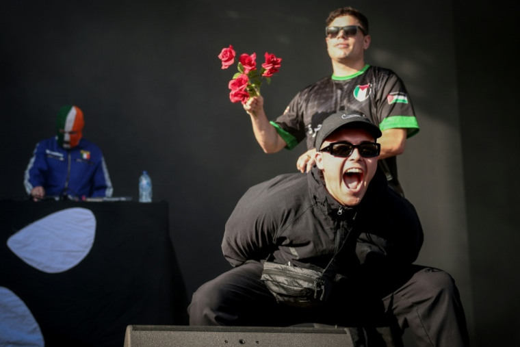 Liam O'Hanna, alias Mo Chara (au centre) et Naoise O Caireallain, alias Moglai Bap (à droite), du trio Kneecap, sur la scène de Rock en Seine le 24 août 2025 à Saint-Cloud, près de Paris ( AFP / Guillaume BAPTISTE )