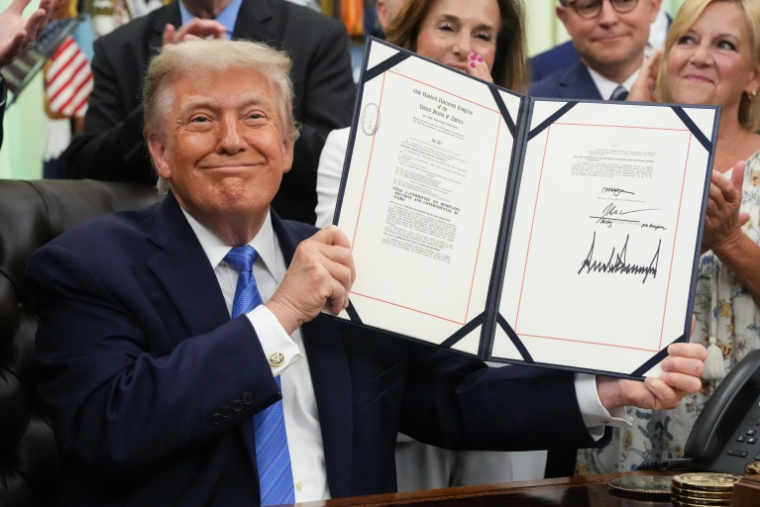 Le président américain Donald Trump montre la signature du le "Secure America Act", dansle Bureau ovale de la Maison Blanche, le 10 juin 2026 à Washington ( AFP / Ken Cedeno )