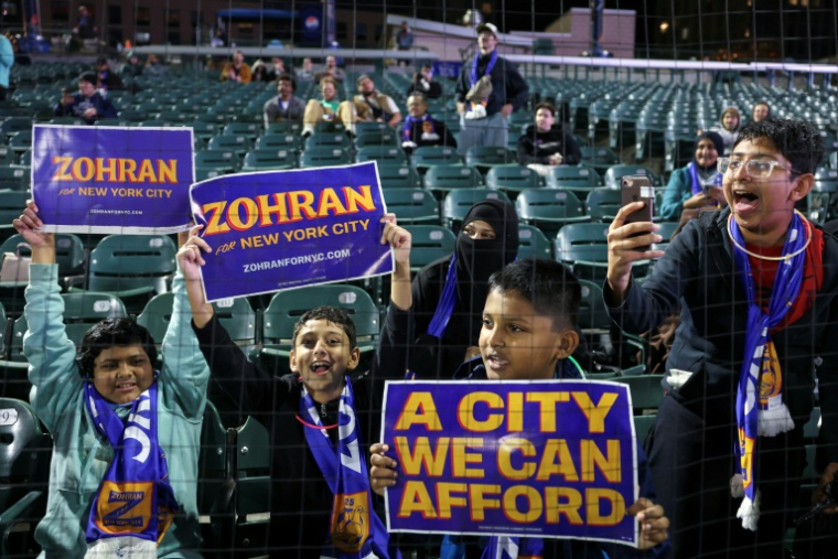 Des garçons brandissant des panneaux en soutien au candidat démocrate pour la mairie de New York Zohran Mamdani, lors tournoi de football le 19 octobre 2025 à New York. ( AFP / ANGELA WEISS )