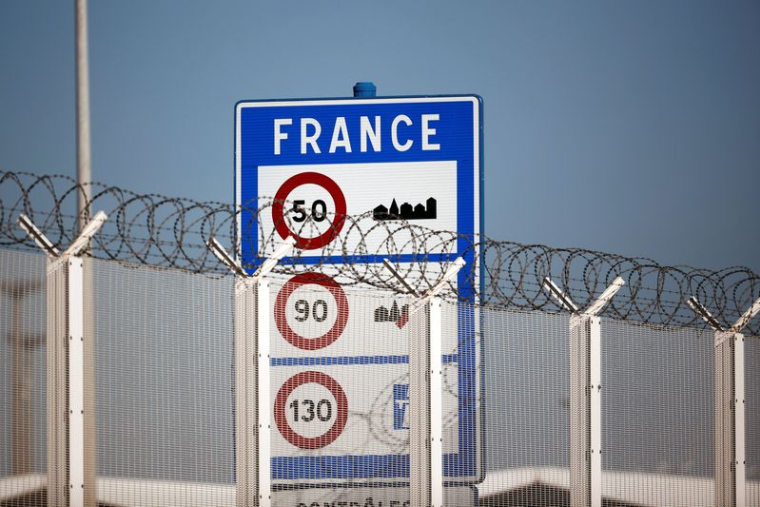 Un panneau frontalier est photographié derrière la clôture du port de Calais