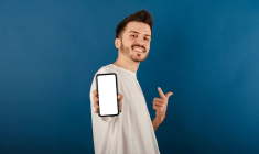 (Crédits photo : Adobe Stock - Jeune homme ravi d'avoir rejoint la banque la moins chère et qui fait deviner le montant de ses économies)