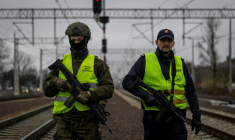 Un garde de la sécurité ferroviaire et un soldat des Forces de défense territoriale patrouillent le long des voies ferrées dans la banlieue de Varsovie, le 27 novembre 2025 en Pologne ( AFP / Wojtek RADWANSKI )