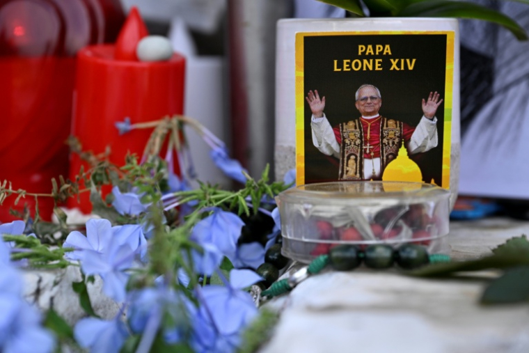 Des fleurs, des bougies et une photo du pape Léon XIV déposées au pied de la statue de Jean-Paul II, devant l’hôpital Gemelli à Rome où le pape Léon XIV est en convalescence, le 17 octobre 2026 ( AFP / Tiziana FABI )