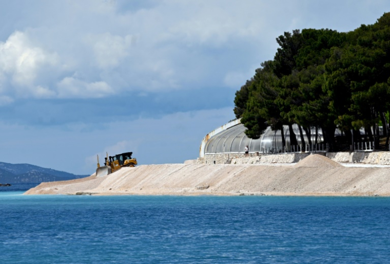 Un engin de chantier drague du sable pour agrandir et consolider une plage artificielle à Primosten, en Croatie, le 9 mai 2025 ( AFP / ELVIS BARUKCIC )