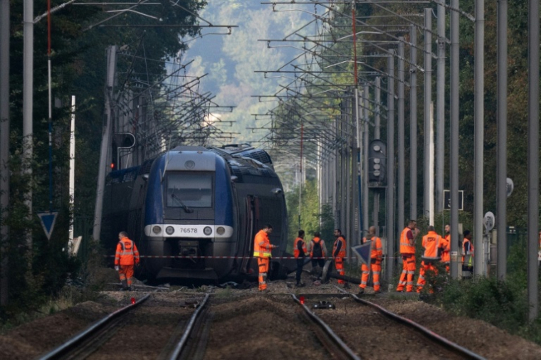 Des agents de la SNCF devant le train qui a déraillé vendredi, Cléon, le 12 septembre 2026 ( AFP / GUILLAUME SALIGOT )