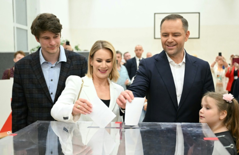Le candidat conservateur Karol Nawrocki (2e d) et son épouse Marta Nawrocka (c) votent au deuxième tour de la présidentielle, accompagnés de leurs enfants Daniel (g) et Katarzyna (d), le 1er juin 2025 à Varsovie, en Pologne ( AFP / Sergei GAPON )