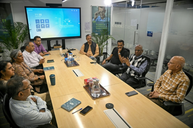 Sridhar Mitta (2e d), fondateur et directeur général de Nextwealth, une société de services basée sur l'IA, participe à une réunion avec son équipe dans ses bureaux à Bengaluru, le 13 janvier 2026 en Inde ( AFP / Idrees MOHAMMED )